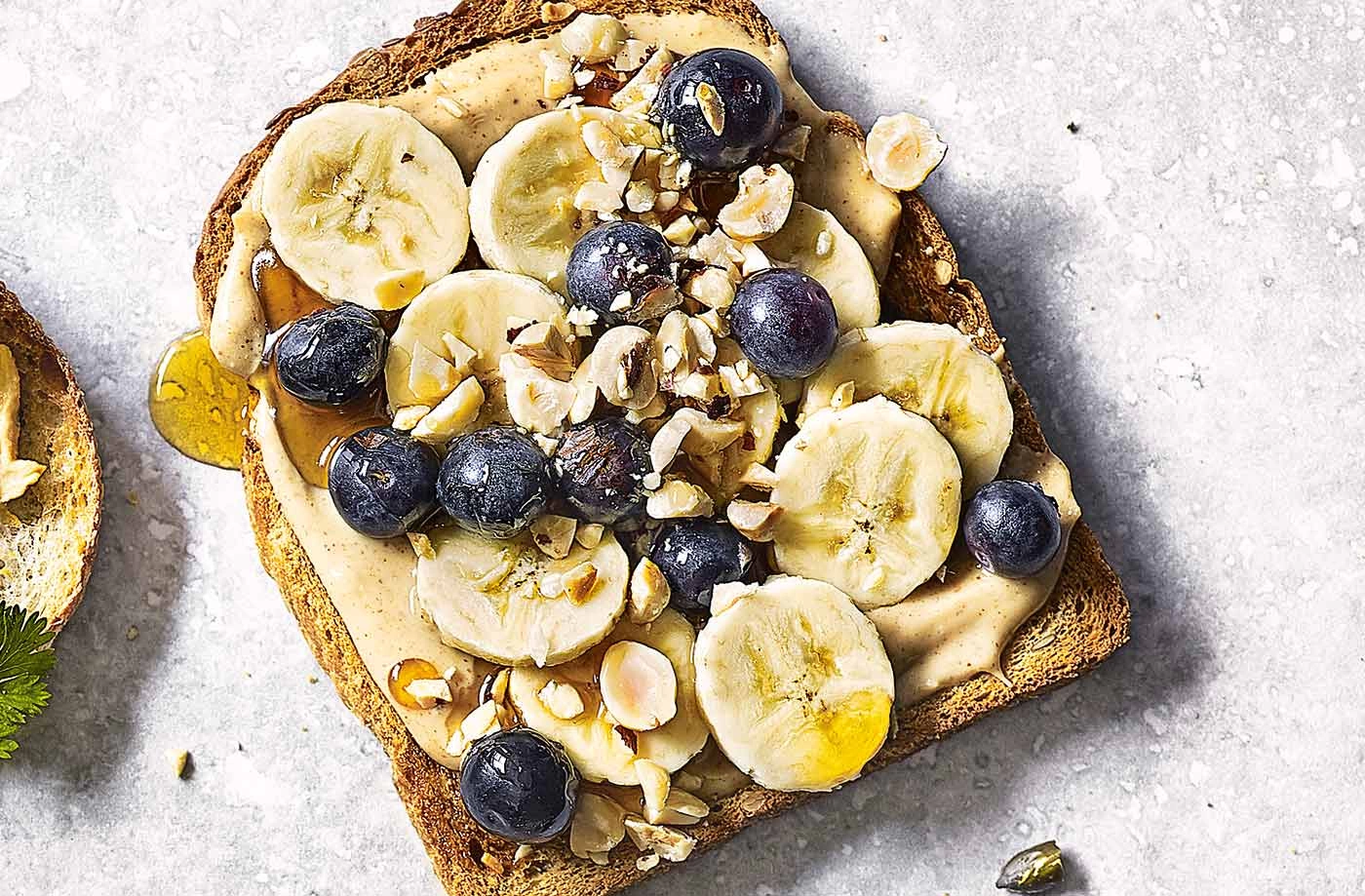 Toast cu unt de arahide, banana, afine, seminte de canepa si sirop de artar